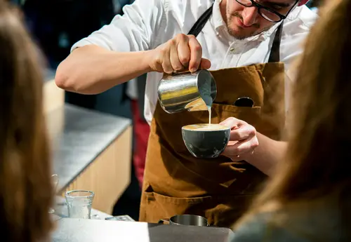 A barista pouring latte art