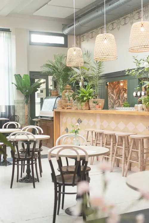 A plant-filled café with marble tables